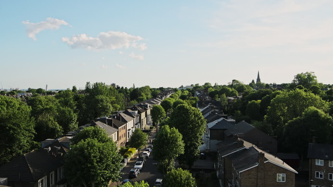 View Of Residential Terraced Housing In Central North London, UK With Lush Trees In The Surrounding - high angle panning shot