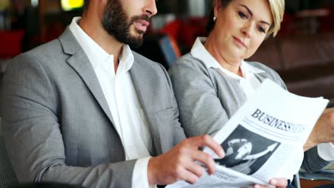 Hombre-De-Negocios-Sosteniendo-El-Periódico-E-Interactuando-Con-La-Mujer