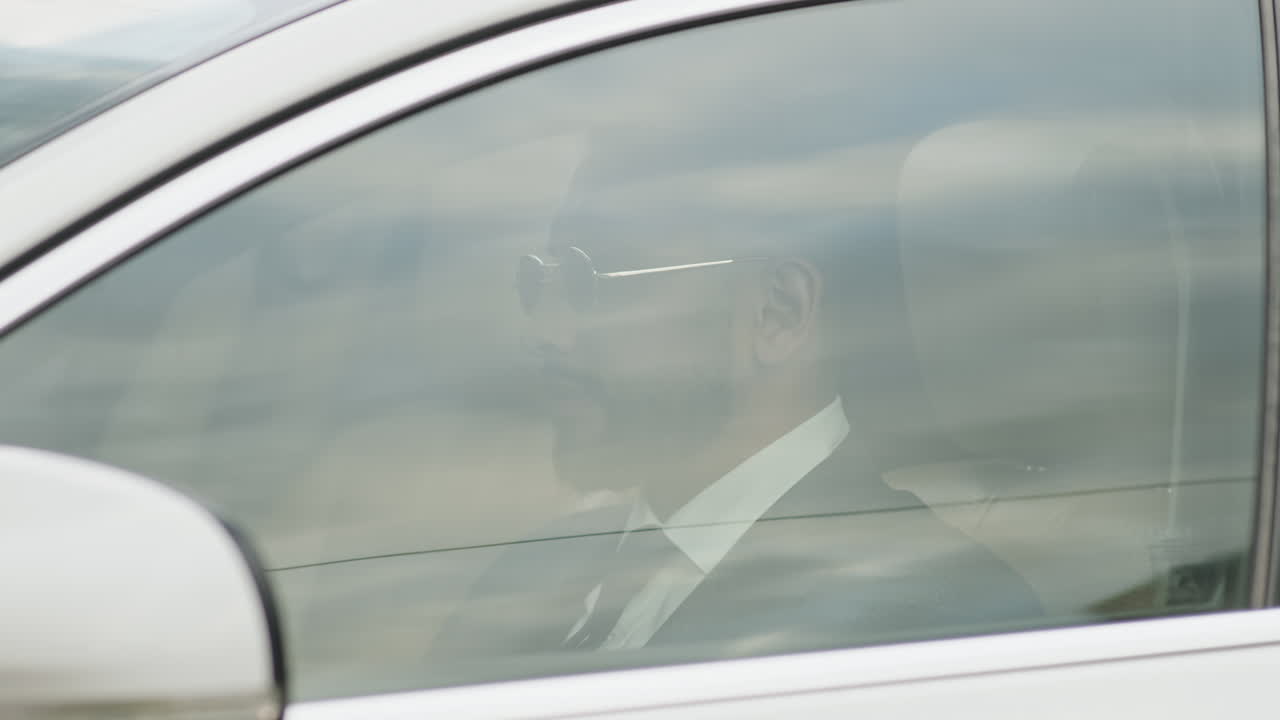 Man Raising Car Window and Driving Away