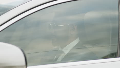 man raising car window and driving away
