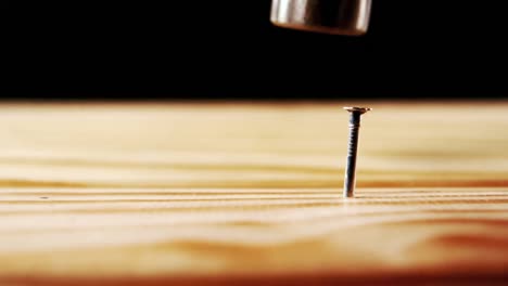 hammer hammering nail into wood