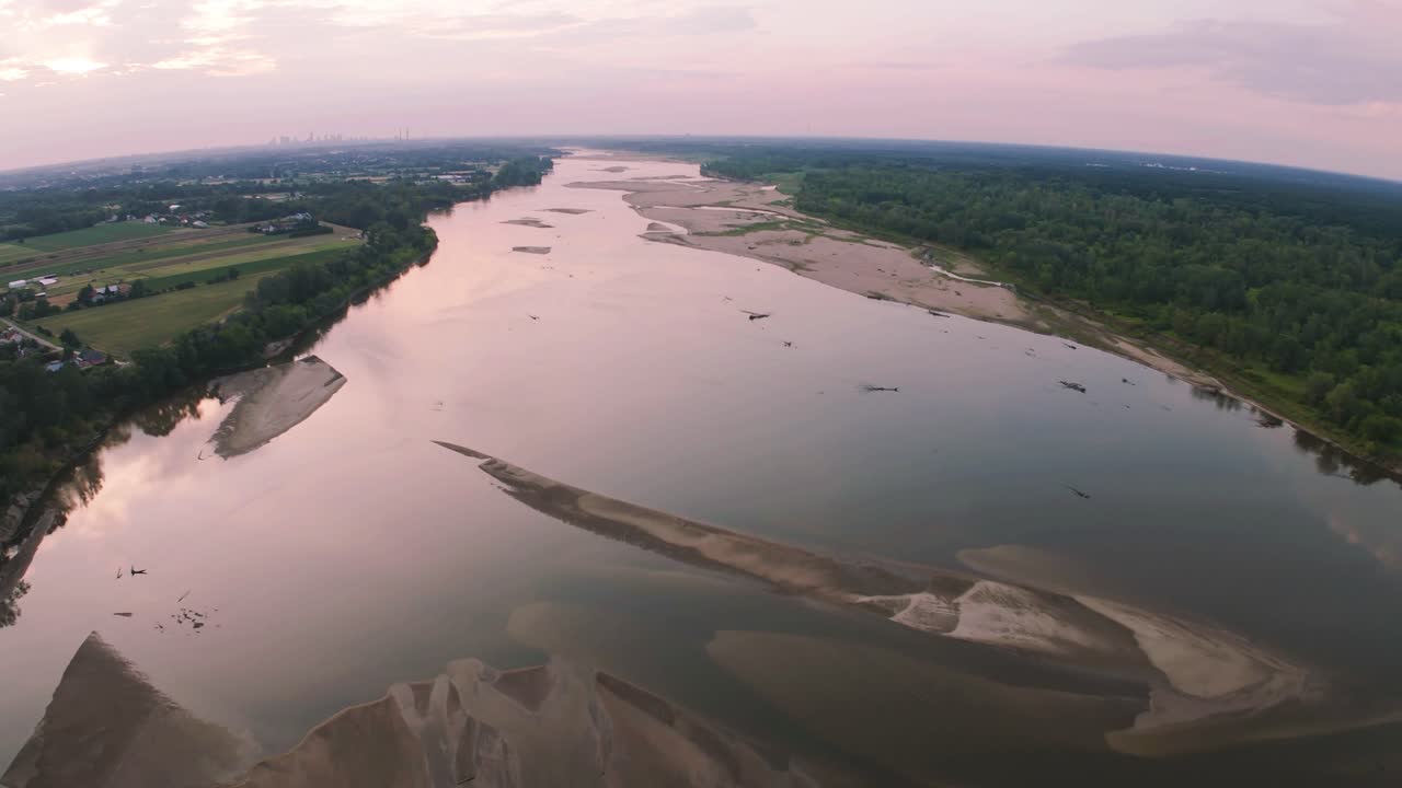 Drone flight over Vistula river towards Warsaw at the sunset