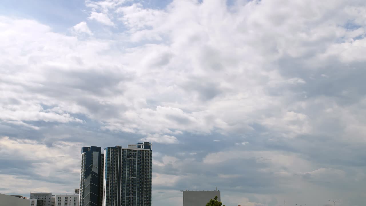 Condomínio e casa à frente de nuvens em movimento no céu e luz natural.