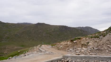 winding dirt road through rocky hills toward deosai national park in astore. gilgit-baltistan, pakistan