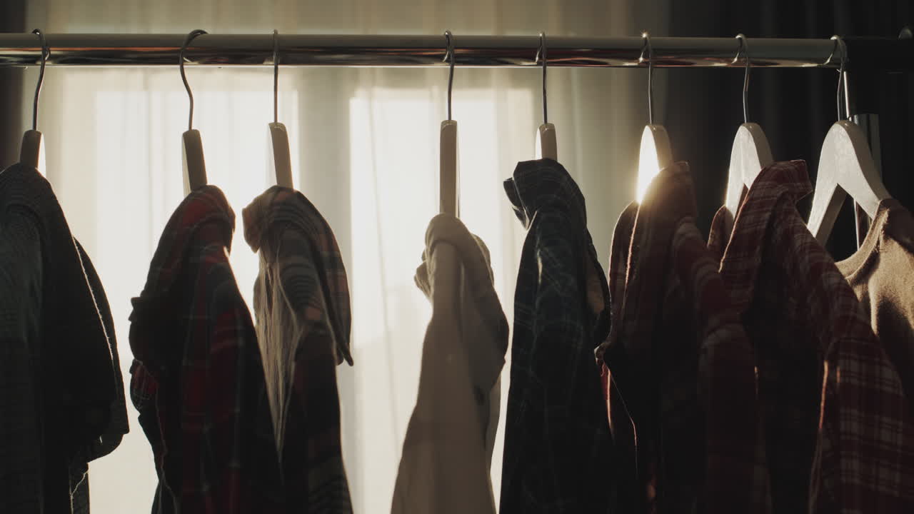 Rack with hangers with men's clothing in front of the window