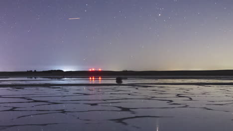 timelapse of moonset and stars in a mirror like lake