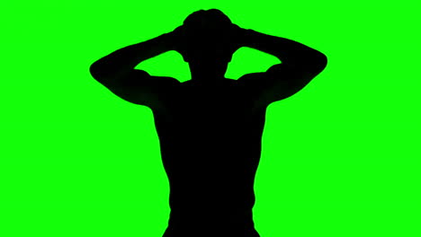 silueta de un hombre tensando los brazos en la pantalla verde