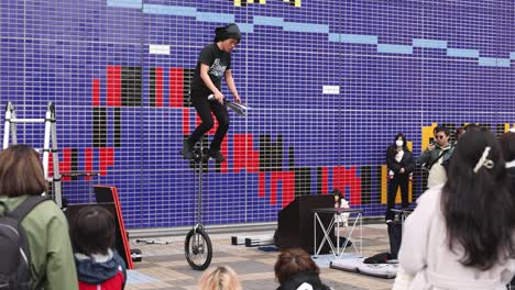 performer riding unicycle in front of audience