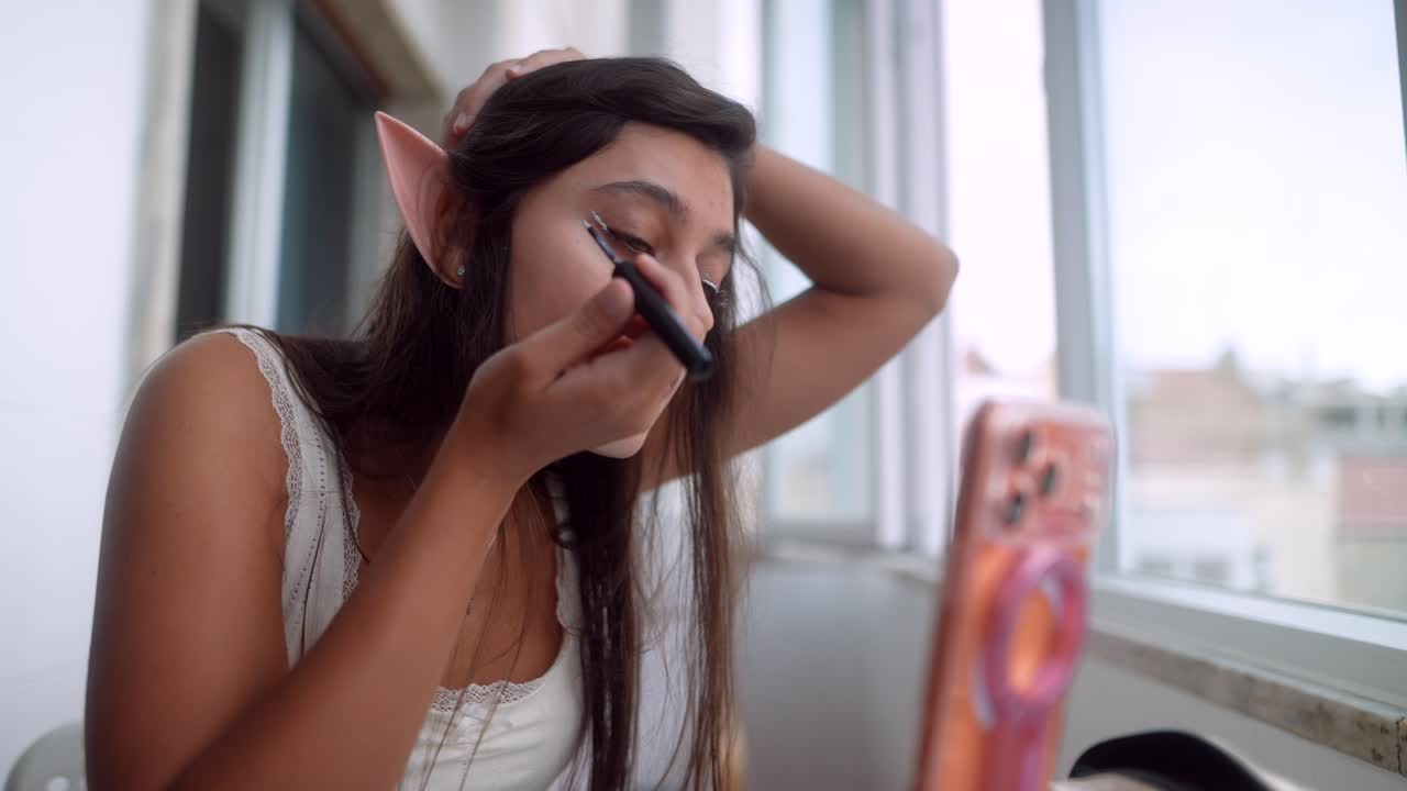Young Woman with Elf Ears Applying Eyeliner for Cosplay