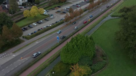 fast aerial of cars driving over road near small town