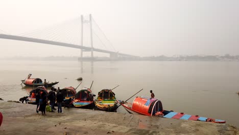 kolkata: timelapse of the colorful boats in the babughat along with the iconic hoogly bridge (vidyasagar setu) in the background