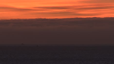 puesta de sol en el océano plano con barco moviéndose cerca de cascais marine