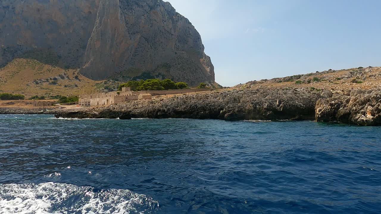 Typical old Sicilian seafront Tonnara Del Secco used for tuna fishing as seen from boat in Sicily