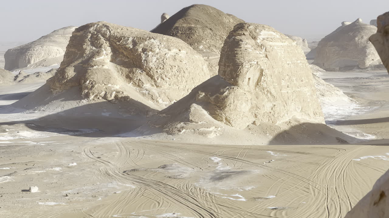 The Egyptian white desert adventure tourism with bedouin camping and 4x4 driving through the desert to see rock formation and sand and dust at sunset and golden hour