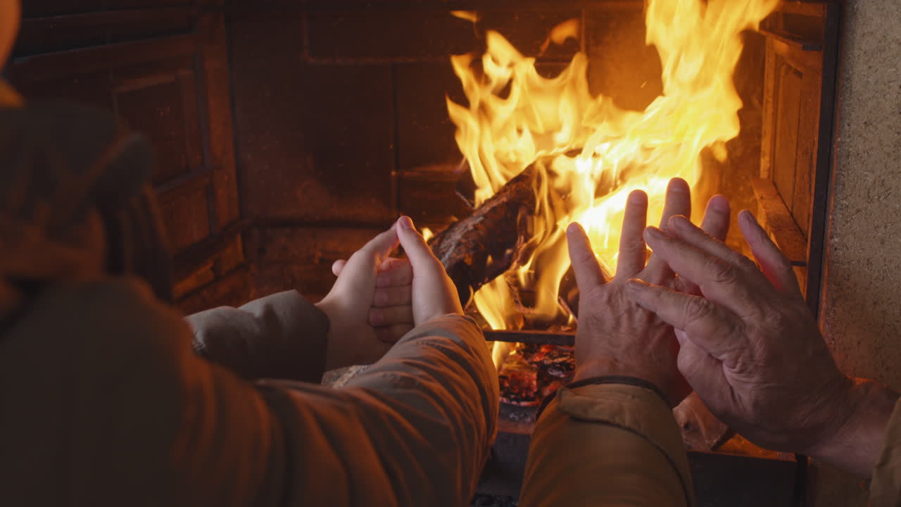 Unrecognizable Child and Man Warming Hands by Fire