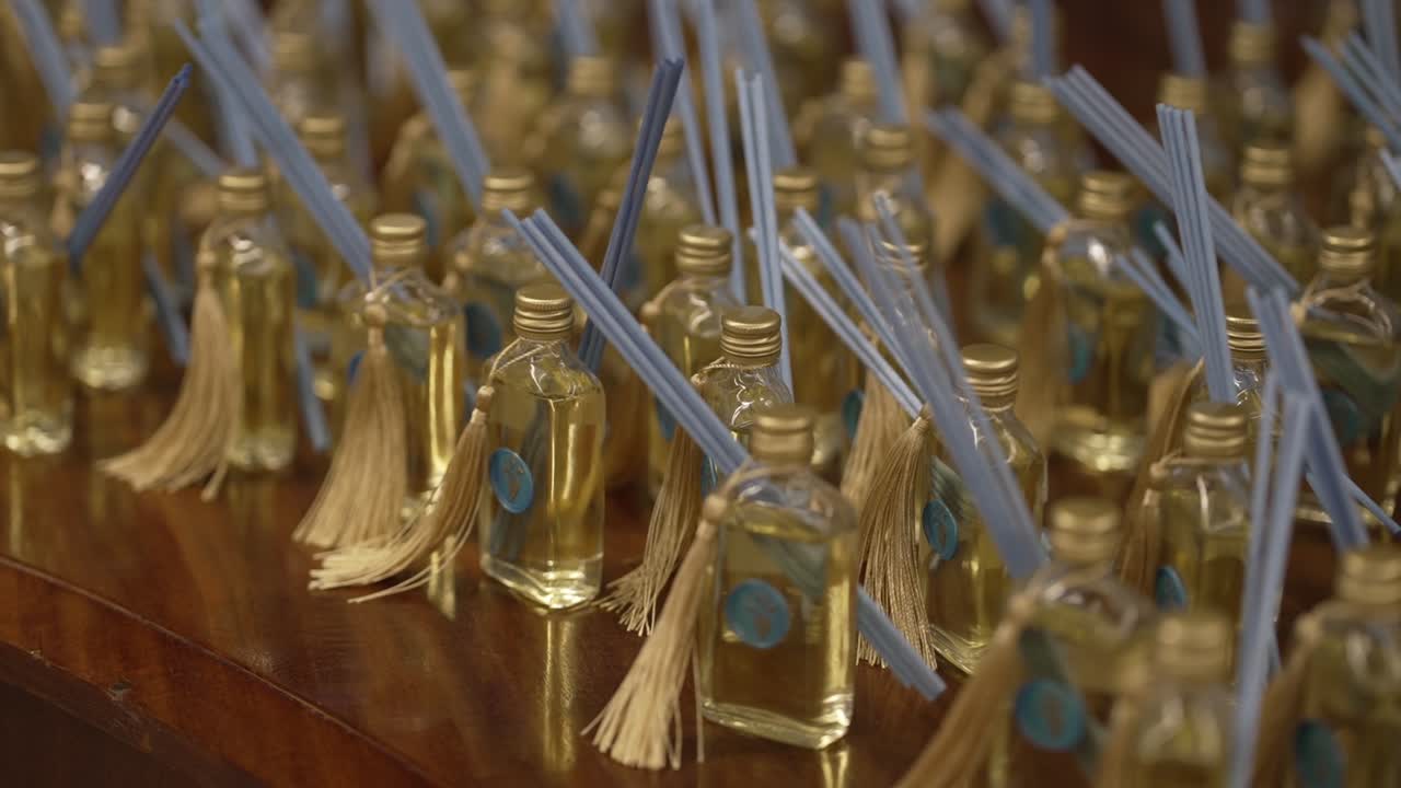 Reed diffuser bottles with tassels arranged on wooden table location irrelevant