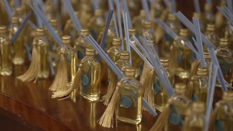 reed diffuser bottles with tassels arranged on wooden table location irrelevant