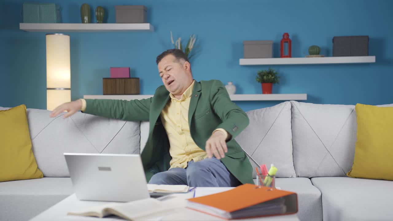 집에서 일하는 사무실 노동자 남자가 일에서 휴식을 취하고 있습니다.