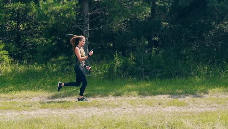 Slow-motion-Side-shot-Young-girl-goes-in-for-sports-in-the-morning-runs-along-pine-forest
