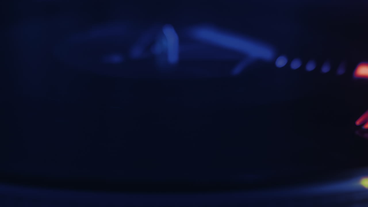 A working record player with a rotating vinyl record. Neon red illumination around