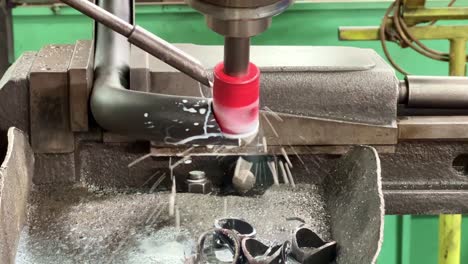 máquina cnc que trabaja cortando tubos metálicos con líquido de enfriamiento