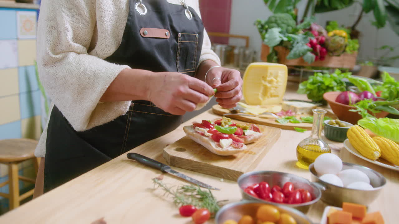 Woman preparing and tasting bruschetta in the kitchen