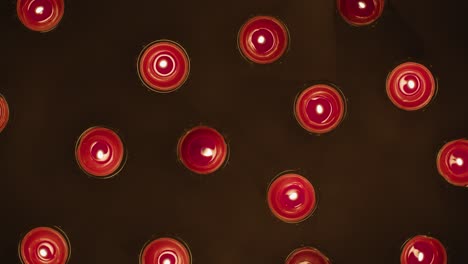 Overhead-Shot-Of-Romantic-Lit-Red-Candles-Revolving-On-Black-Background