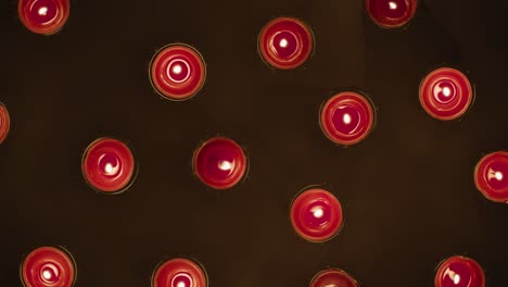 overhead shot of romantic lit red candles revolving on black background