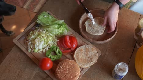 cook preparing a delicious veggie burger adding vegan mayo in 4k slow motion