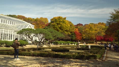 People-in-masks-visiting-and-walking-by-Grand-Greenhouse-of-Changgyeonggung-Palace,-Seoul,-South-Korea,-Cultural-Heritage