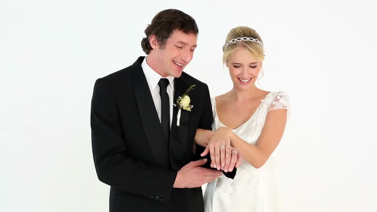 신혼 부부 들 이 결혼 반지 를 감상 하고 있다