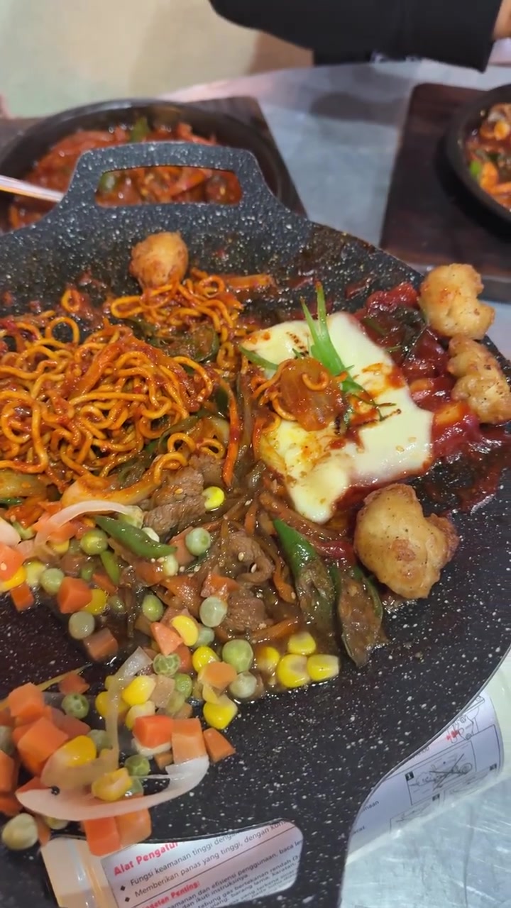 Orang Menyendok Campuran Sayuran dari Hidangan Hot Plate