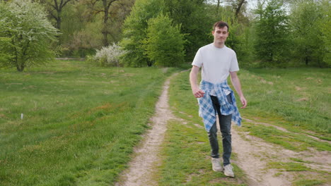 young man walking on a country path