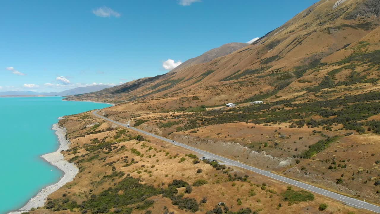 vista aérea de una carretera junto al lago hasta el lago pukaki, nueva zelanda, mientras una caravana conduce
