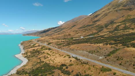 Luftaufnahme-Einer-Straße-Am-Seeufer-Zum-Lake-Pukaki,-Neuseeland,-Während-Ein-Wohnmobil-Weiterfährt