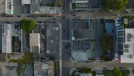 Vertically-panning-footage-of-cars-driving-in-city-streets-from-directly-above.-Roads-in-urban-borough-lined-by-buildings.-Miami,-USA