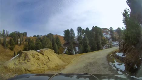 suv driving through narrow and steep mountainous roads covered with snow during winters