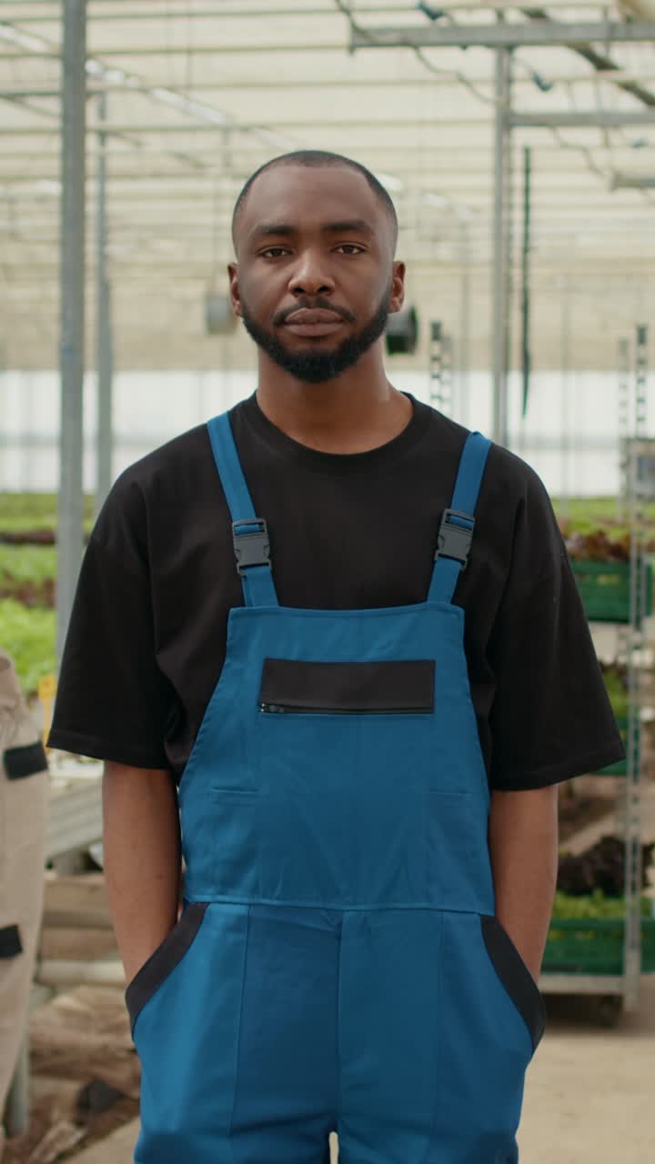 Portrait of african american farmer posing with arms crossed in modern greenhouse