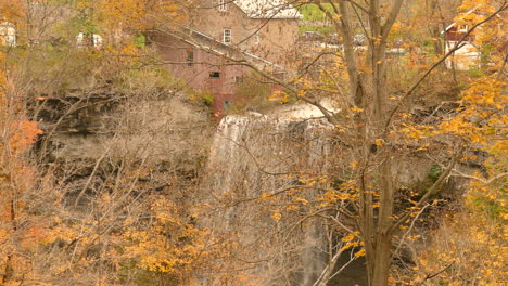 Blick-Von-Oben-Nach-Unten-Auf-Einen-Wasserfall,-Der-In-Einer-Natürlichen-Umgebung-In-Einen-Bach-Mündet