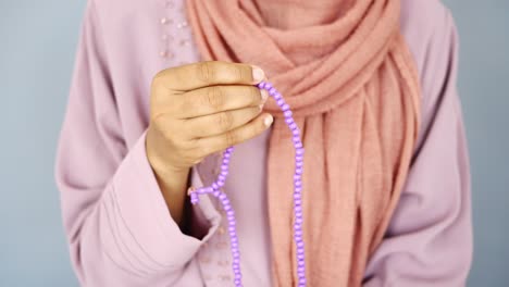 woman praying with prayer beads