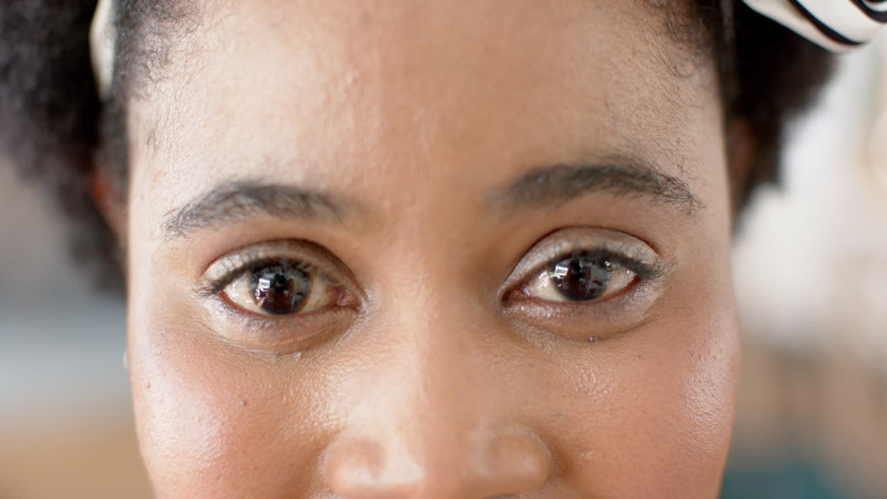 Close-up of an African American woman with a subtle smile and brown eyes at home