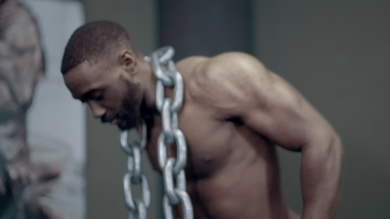 Fit African American man performs weighted dips