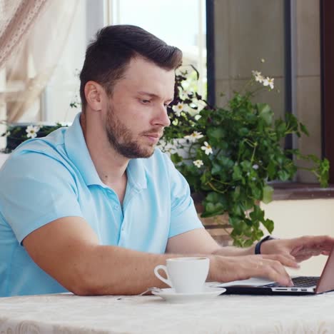 el hombre bebe café y usa una computadora portátil