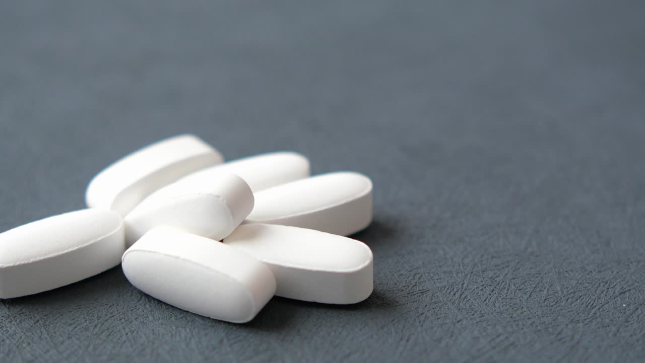 어두운 회색 표면에 색 타원형 알약