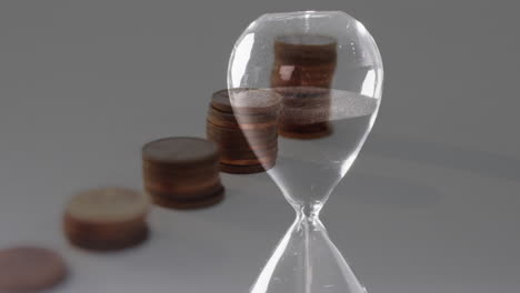 animación de pilas de monedas sobre un reloj de arena