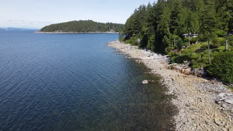 Rocky,-tree-line-shore-of-Canoe-Bay-Beach-on-the-picturesque-Sunshine-Coast-of-British-Columbia,-Canada