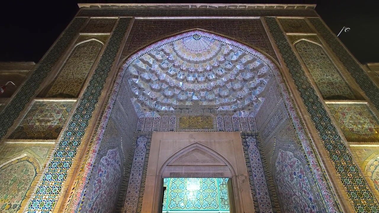 Ingresso piastrellato con intricati mosaici di una moschea storica di notte
