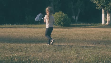 young-lady-walks-holding-blue-butterfly-net-in-hand