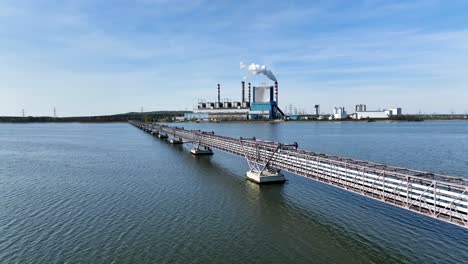 drone-fly-above-warta-river-in-konin-Poland-revealing-old-coal-power-plant-station-at-distance