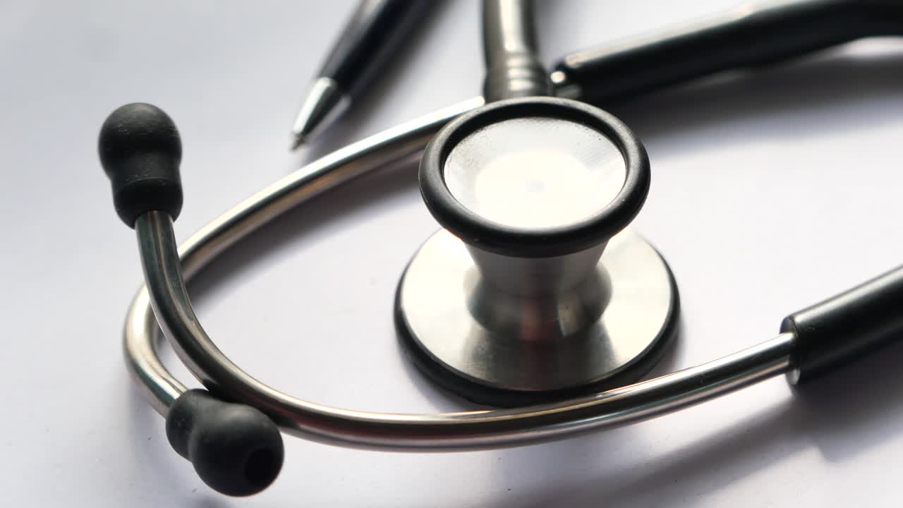 stéthoscope et stylo sur une surface blanche